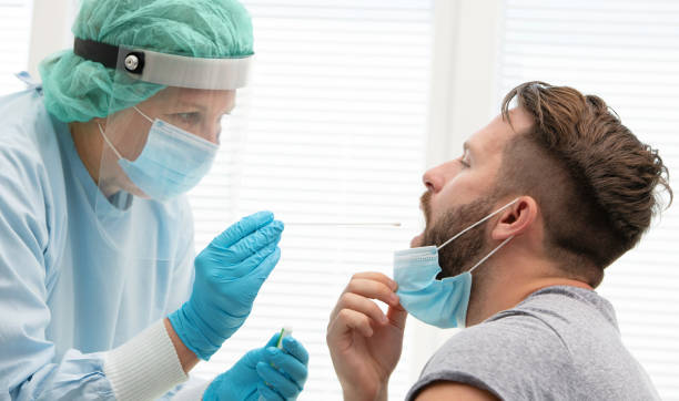 médico que prueba al paciente sobre una posible infección por coronavirus - specimen holder fotos fotografías e imágenes de stock