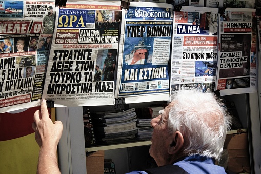 Greece, Athens, August 11 2020 - People reading the news at a press kiosk in the center of Athens, on a day of high tension between Greece and Turkey, after the Turkish seismic research vessel Oruc Reis entered the Greek territorial waters for a seismic survey.