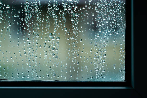 istock Macro raindrops vapor on window glass. Rain drops on window glasses surface. Through the window view. Drops of rain on glass. Water pattern texture 1266090925