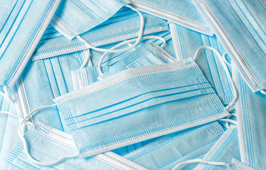 Close-up of a collection of disposable, single-use face masks.