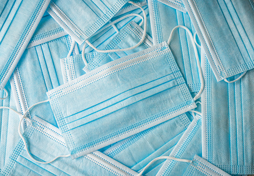 Close-up of a collection of disposable, single-use face masks.