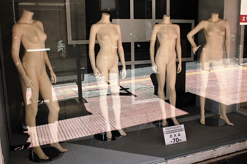 Greece, Athens, August 11 2020 - The window of empty clothing store in the commercial center of Athens, with mannequin dolls in the display.