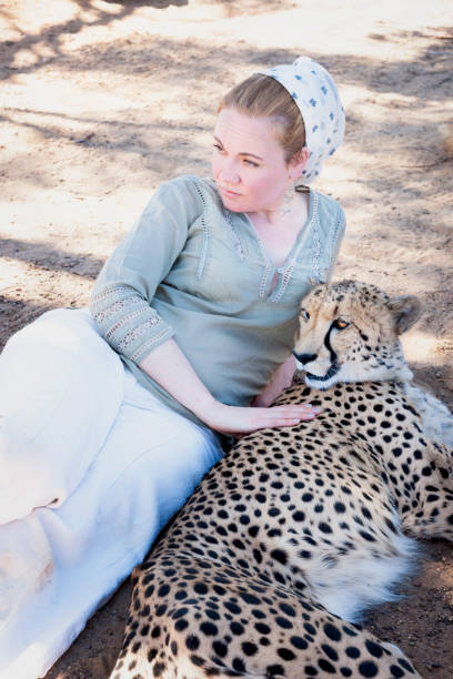 istock Woman lying beside a cheetah 1266092919
