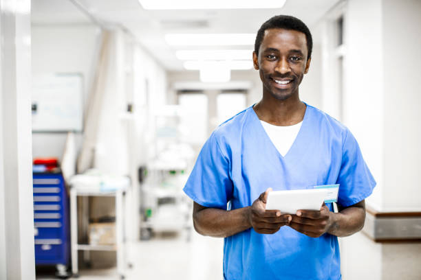 istock Smiling young doctor using a digital tablet in a hospital hallway 1266097952