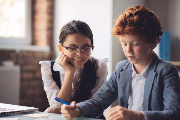istock Dark-haired girl explaining lesson to her classmate 1266100399