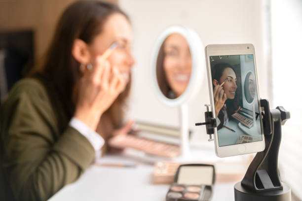 istock Happy beauty influencer recording content at home putting make-up on 1266103804