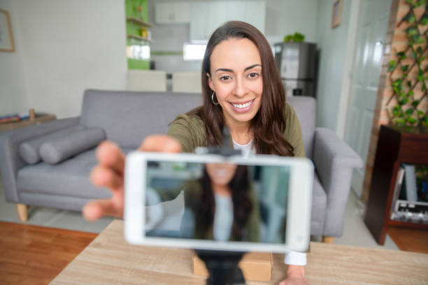 istock Happy female influencer recording content at home using her cell phone 1266103826