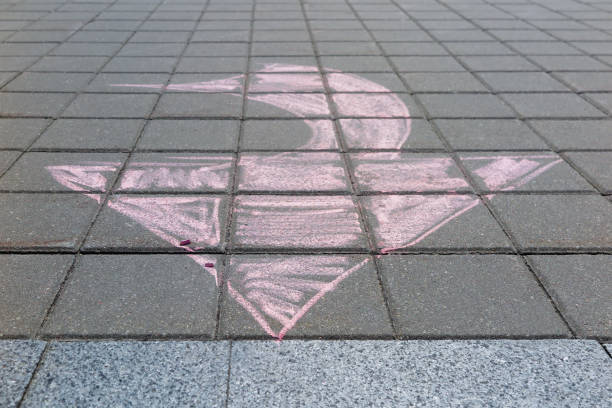 Arrow drawing with chalk on the paving tiles.