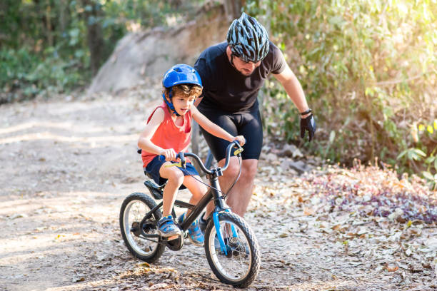 istock Instructor teaching child to ride a bike 1266105889