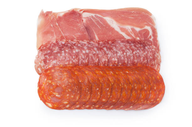 Studio shot of a mixture of Italian and Spanish cold meats, prosciutto, salami and chorizo cut out against a white background.