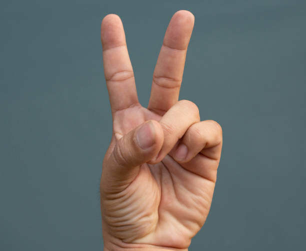 istock Two fingers raised on blue back ground. symbol concept. 1266109811