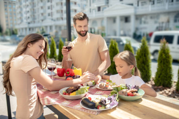 istock Young family having dinner outside and looking happy 1266110039