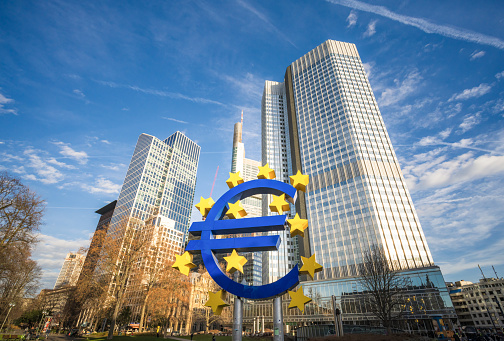 Frankfurt, Germany - The Euro Symbol, a sculpture by Ottmar Hörl, with the office towers of Frankfurt's central business district in the background.
