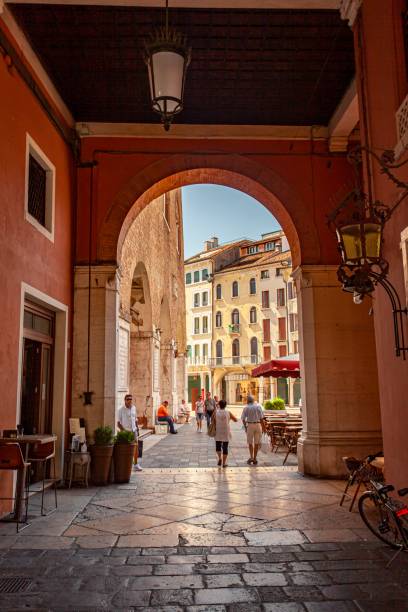 arkady na piazza dei signori w treviso z ludźmi przechodzącymi przez 2 - tower treviso veneto palace zdjęcia i obrazy z banku zdjęć