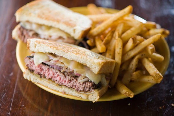 istock Bacon cheeseburger. Classic American style hamburger with all beef patties, crispy Bacon, melted Swiss & cheddar cheese, caramelized onions, lettuce, tomato, on a toasted brioche bun & served w/ crispy French fries. American Bar food favorite. 1266114314