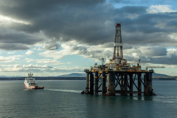 Anchor Handling Tug Ship Siem Garnet towing the Semi Submersible Sedco 714 at Cromarty Firth INVERGORDON, SCOTLAND - 2016 MARCH 09. Anchor Handling Tug Ship Siem Garnet towing the Semi Submersible Sedco 714 at Cromarty Firth. ballast water stock pictures, royalty-free photos & images