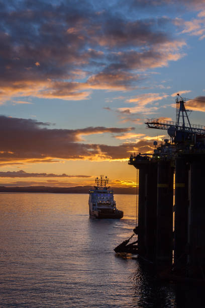 statek offshore robi ruch platformy o zachodzie słońca w cromarty firth szkocji. - crane oil well derrick crane floating oil production platform zdjęcia i obrazy z banku zdjęć