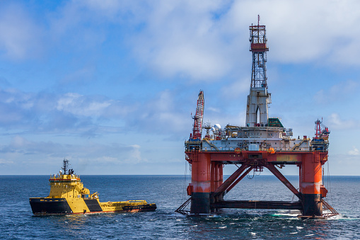 NORTH SEA NORWAY - 2015 MAY 25. The semi-submersible drilling rig Transocean Leader with anchor handler vessel Balder Viking alongside.