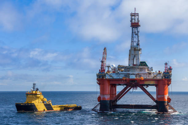 The semi-submersible drilling rig Transocean Leader with anchor handler vessel Balder Viking alongside. NORTH SEA NORWAY - 2015 MAY 25. The semi-submersible drilling rig Transocean Leader with anchor handler vessel Balder Viking alongside. ballast water stock pictures, royalty-free photos & images