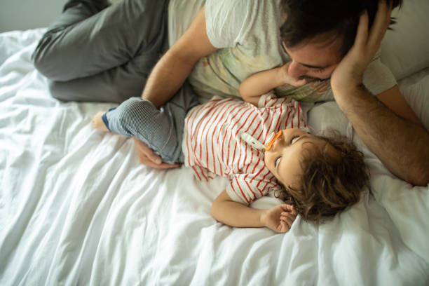 istock Father and son taking a nap on bed at home 1266114447