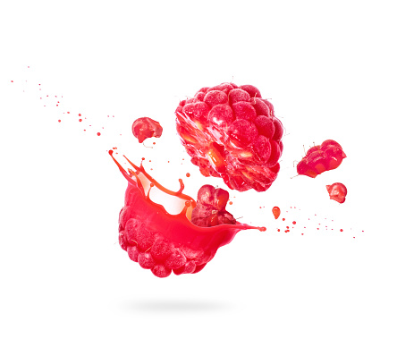 Raspberry cut into two halves with flowing juice close-up on white background