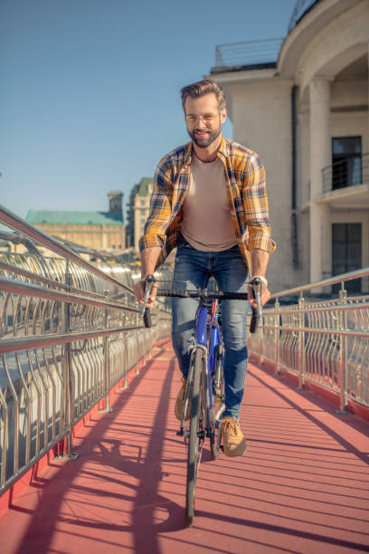 istock Man on bicycle riding road straight to camera 1266119883