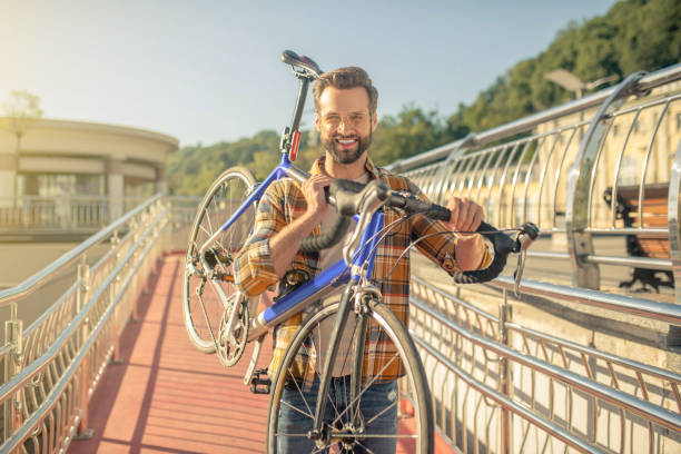 istock Smiling man carrying bicycle on sunny day 1266119885