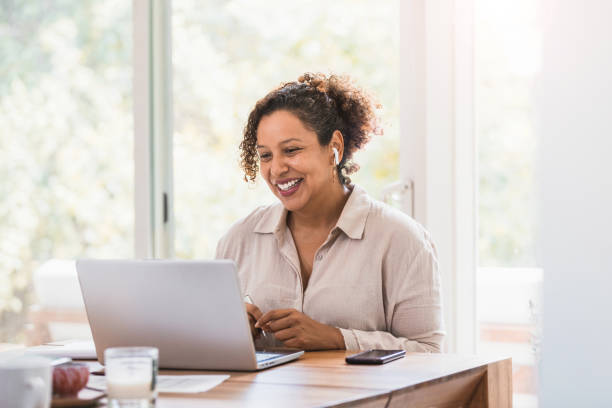 istock Woman with bluetooth earbuds smiles during video conference 1266123456