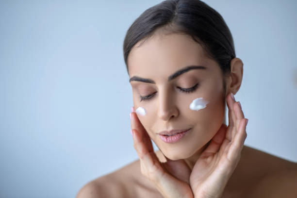 istock Cute woman with cream on her cheeks looking relaxed 1266123625