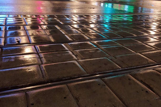 istock pavement wet from the rain with reflective lights in the evening 1266125193