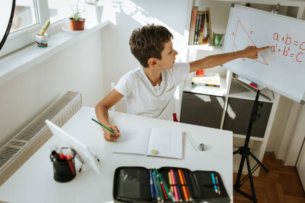 istock School boy is solving mathematics task during online class. Homeschooling during COVID-19 Pandemic. 1266126368