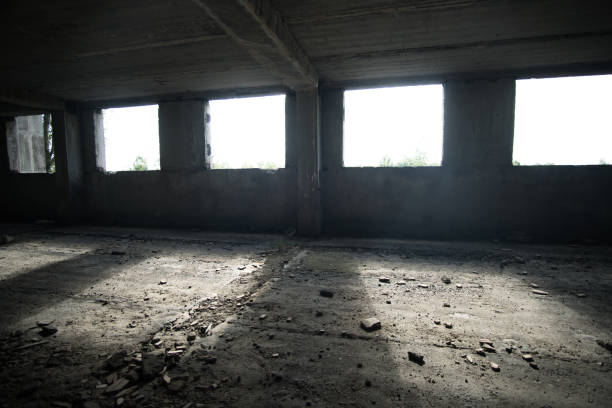 istock Interrior of an unfinished abandoned building illuminated by rays of light  through the windows. 1266127171