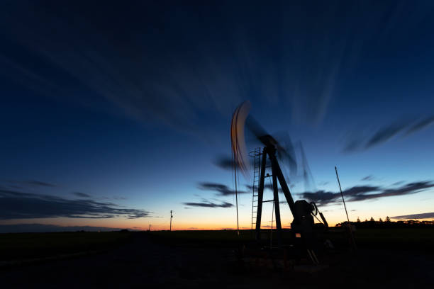 Prairie Oil Pump Jacks Canada USA Night image of oil pump jack working, long exposure. Image taken from a tripod. oil pump petroleum equipment development stock pictures, royalty-free photos & images