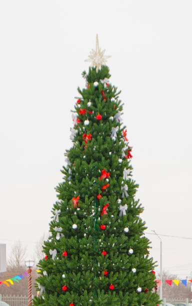 istock Beautiful Christmas tree decorated with balloons, bows and a star on a white background 1266127384