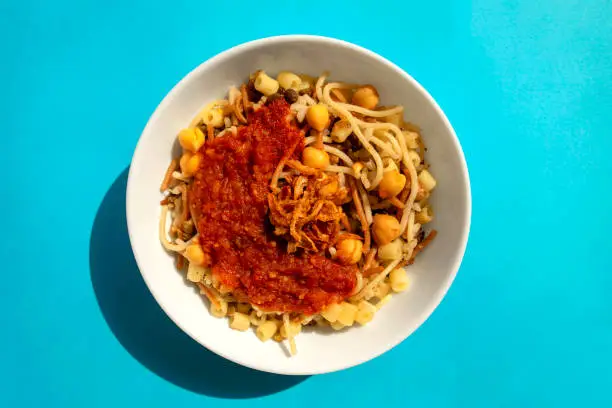 Photo of National Kushari in a white plate on a blue background