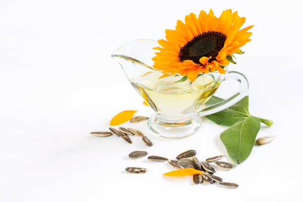 sonnenblumenkopf, öl und samen auf dem weißen hintergrund. gesunde natürliche sonnenblumenprodukte. - sunflower seed oil stock-fotos und bilder