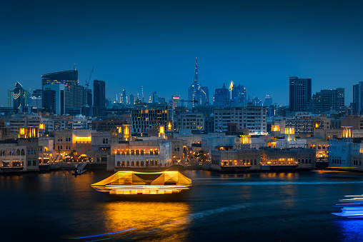 Dubai modern skyline panoramic view from the creek and the old city in Deira in United Arab Emirates at blue hour