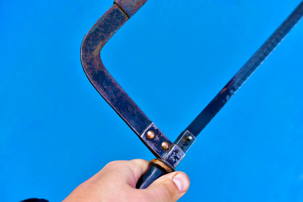 istock Metal hacksaw in hand on a blue background 1266133347