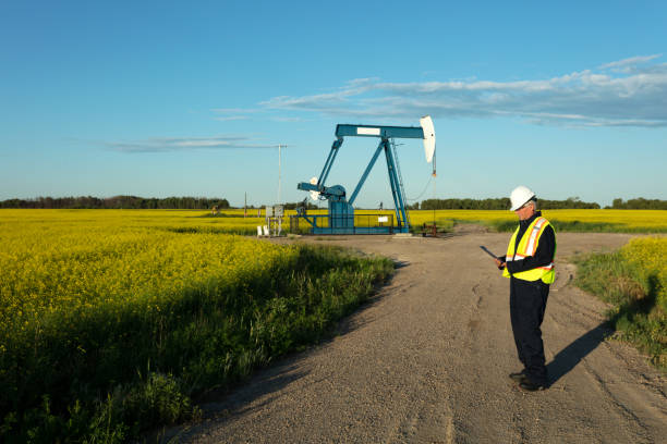 olio lavoratore sicurezza gear prairie oil - manitoba canada prairie canola foto e immagini stock