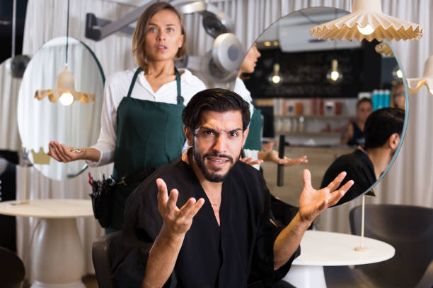 male visitor shocked in salon male visitor shocked by thr work female hairdresser in salon angry hairstylist stock pictures, royalty-free photos & images