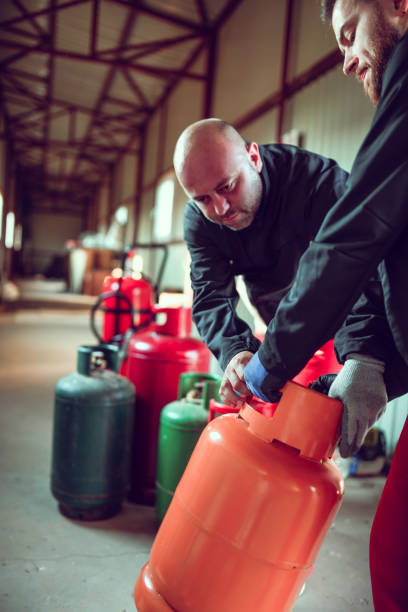 istock Workers Preparing To Refill Gas Cylinder 1266137728