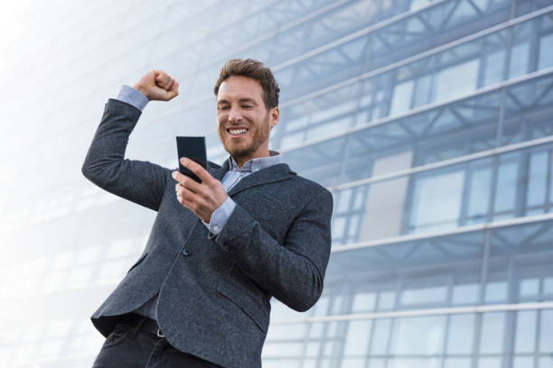 istock Success winner business man winning on cellphone 1266144382