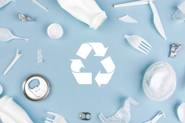 istock Top view of Different garbage materials with recycling symbol on blue background 1266144598