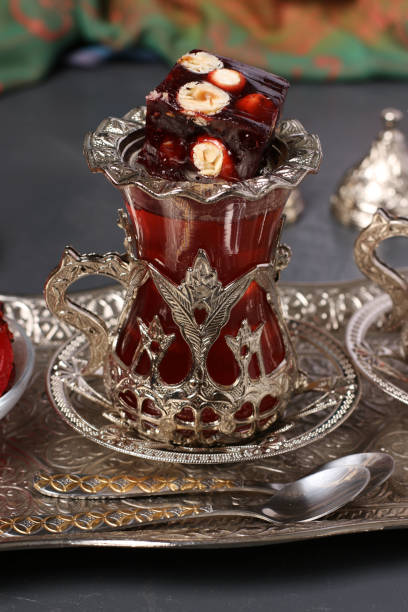istock Pomegranate tea and turkish delight on metal tray on dark background, Closeup, Vertical format 1266144607
