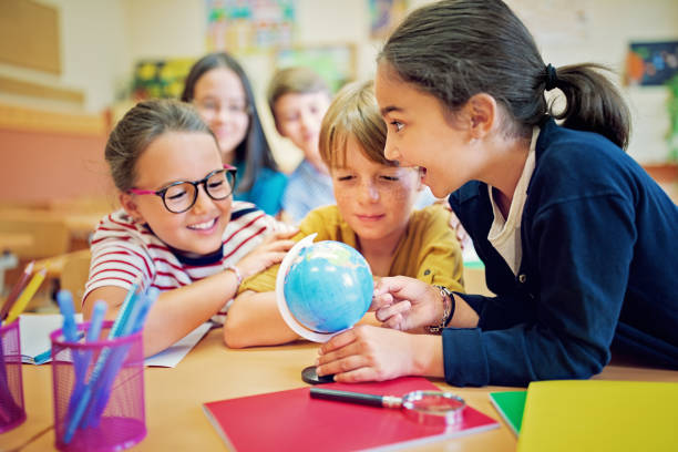 istock School children are examining a globe in the classroom 1266146618
