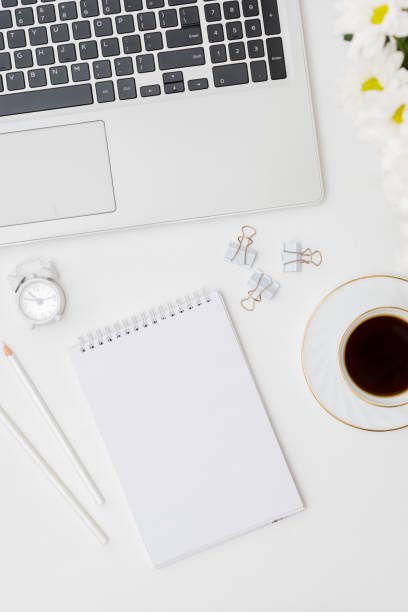 istock Mockup white notebook, laptop a cup of coffee on a white background 1266146890