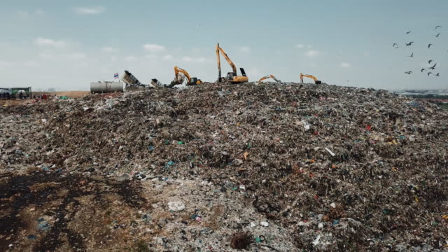 Aerial view landfill with garbage trucks unloading junk