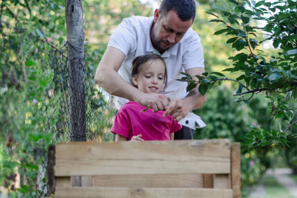 istock Father and daughter composting outdoors 1266151638