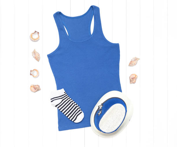 istock Blue tank top with seashells and straw hat on a white background 1266154610