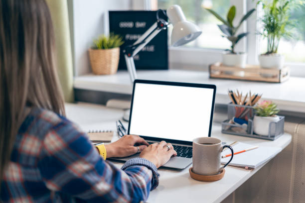 istock Cropped woman typing on laptop computer while sitting at home. Close up hands with mockup monitor. Distance learning online education and work 1266154802